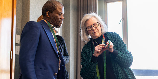 Prof Michele Ramsay shows Wits VC Prof Zeblon Vilakazi how a beaded necklace featured on the cover of Nature in 2020 depicts a genetic sequence 600x300.